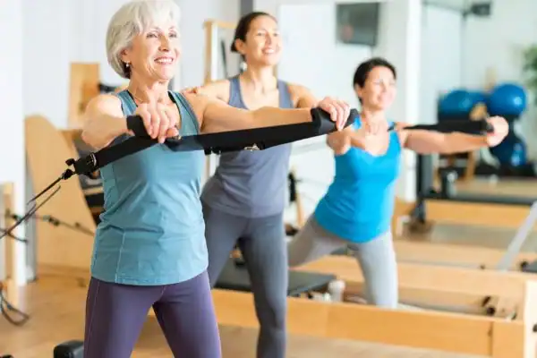Toning Arms After 60: Empowering Womens Fitness Through Effective Weight Training 2 older woman doing weight training Littlehampton and resistance in the gym to tone upper arms