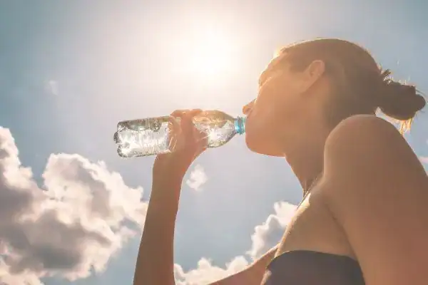 Hydration: The Secret Ingredient for a Toned Stomach and Enhanced Fitness 3 Image of woman drinking water to hydrate Littlehampton after run.